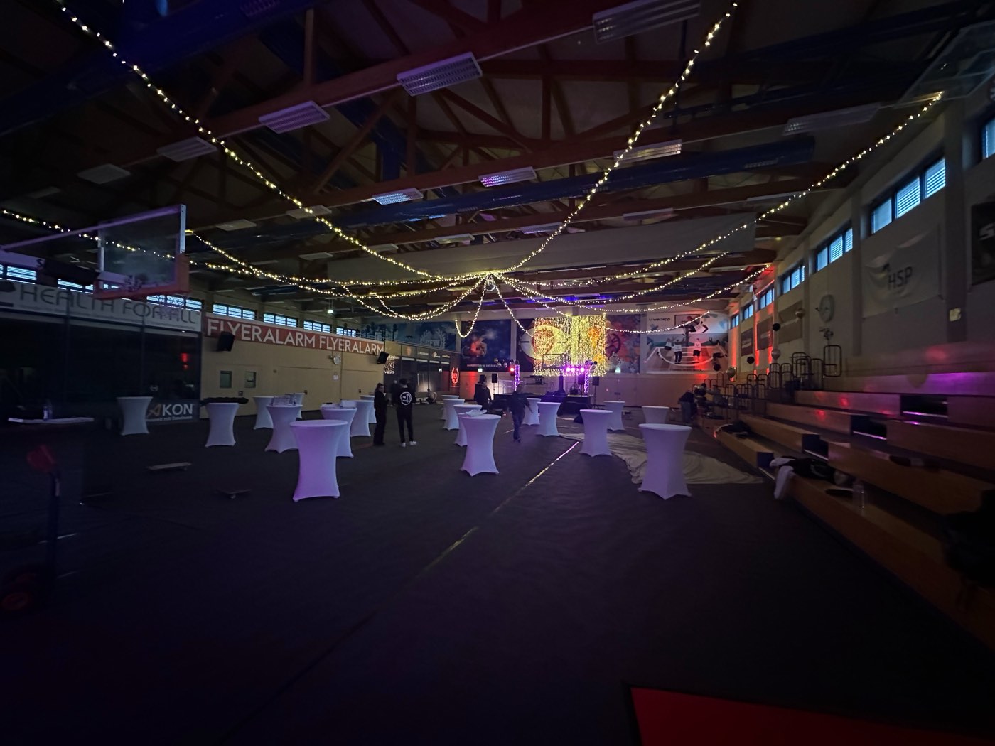 Abendveranstaltung mit Lichterketten und Stehtischen in der Halle