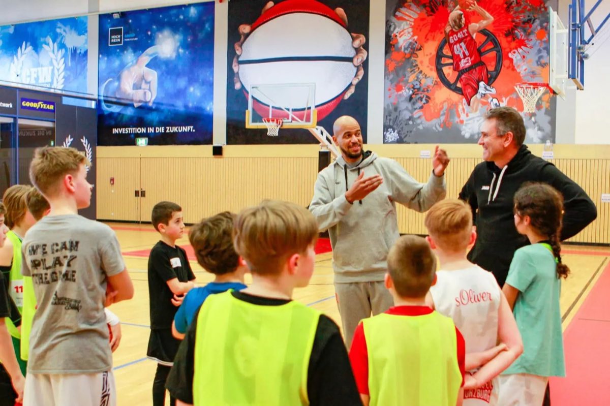 Basketball-Profi im Gespräch mit Kindern in der Arena